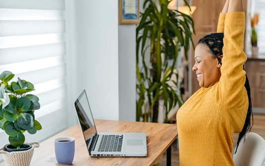 A woman stretching at her desk