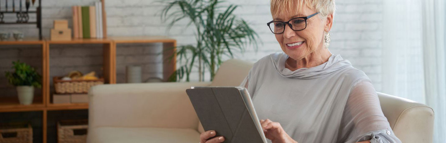 A woman looking at her tablet with interest