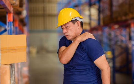 Un homme en douleur qui se tient l’épaule     