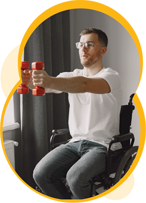 A person with light skin sitting in a wheelchair in their home. They are holding dumbbells in their hands, with their arms stretched out in front of them.