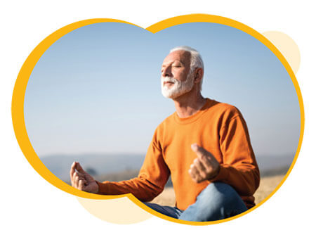 Un homme âgé aux cheveux et à la barbe grisonnants, assis, méditant