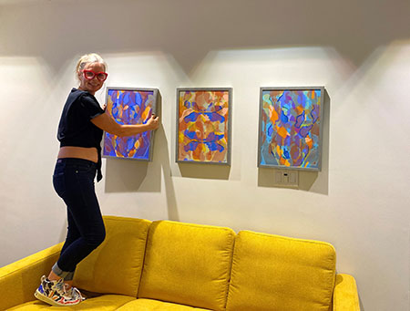 Kate Kilty hanging her paintings