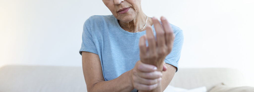 elderly woman suffering from pain hand arthritis